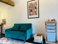 a blue couch in a room with a book shelf at Le Planzollais in Planzolles