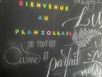 a chalkboard with writing on it with a flower on it at Le Planzollais in Planzolles