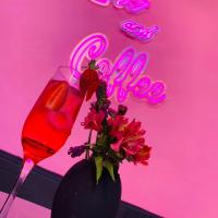 un bicchiere di vino con fiori e un'insegna al neon di Casa Rosa Hotel & Spa a San Cristóbal de Las Casas