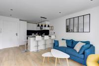 a living room with a blue couch and a kitchen at 322 Suite Fes - Superb apartment in Suresnes