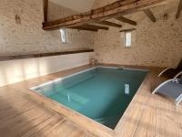 a large swimming pool in a room with a wooden floor at Les gîtes de La Pellerie - 2 piscines &amp; spa Jacuzzi - Touraine - 3 gîtes - familial, calme, campagne in Saint-Branchs