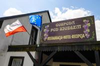 twee vlaggen bovenop een gebouw met een bord bij Ośrodek LBN-HUTA in Huta