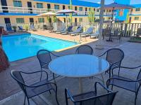 Una mesa y sillas junto a una piscina. en Hotel Confort Plaza, en Culiacán