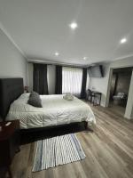 Un dormitorio con una cama grande y una sala de estar. en La casona Talpen, en Constitución