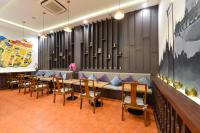 a restaurant with a couch and tables and chairs at Villa De Pranakorn in Bangkok