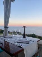 a table with wine glasses and a view of the ocean at Le Capase Resort Salento in Santa Cesarea Terme