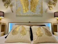 a bedroom with two gold butterfly pillows on a bed at L&#39;Ange Au Sourire in Reims
