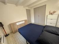 a bedroom with a blue bed and a refrigerator at Appartement in Le Boulou