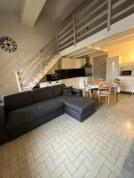 a living room with a couch and a dining room at Appartement in Le Boulou