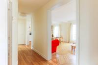 sala de estar con sofá rojo y mesa en Beautiful 95m2 flat in the heart of Neuilly Sur Seine, en Neuilly-sur-Seine