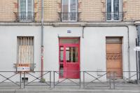 a red door on the side of a white building at Flowers Power - Appt pour 2 in Vitry-sur-Seine