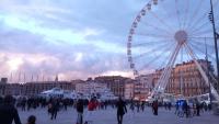 a ferris wheel in a city with a crowd of people at Le Passe-Port pour Marseille in Marseille