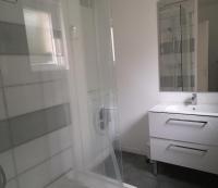 baño blanco con ducha y lavamanos en Hébergement canal, en Villeder