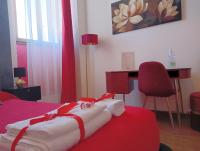 a bedroom with a bed with a desk and a red blanket at Brà Guest House in Verona