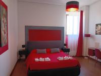 a bedroom with a red bed with two towels on it at Brà Guest House in Verona