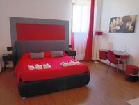 a bedroom with a red bed and a table and chairs at Brà Guest House in Verona