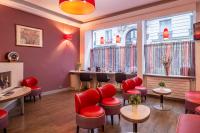 a barber shop with red chairs and tables and windows at Grand Hôtel De Turin in Paris