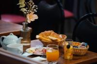a table with a basket of bread and orange juice at Grand Hôtel De Turin in Paris