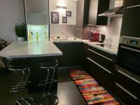 a kitchen with black cabinets and a white counter top at L&#39;Harmonie de Naya, confort , parking privé in Bourges