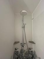 a shower in the corner of a room at Le petit coin de Paradis in Varaville