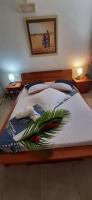 a bedroom with a bed with a flower arrangement on it at Fetay Jaune in Baie-Mahault