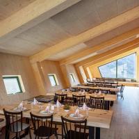 een grote kamer met houten tafels en stoelen bij Tungestølen in Veitastrond