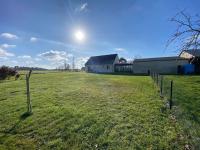 a field with a fence in front of a building at La belle des champs in Luzillé