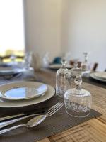 a wooden table with plates and glass jars and silverware at La belle des champs in Luzillé