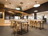 um restaurante com mesas e cadeiras em uma sala em ibis budget Poitiers Site du Futuroscope em Chasseneuil-du-Poitou