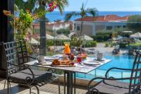 a table with food on it with a view of a pool at Lindos Imperial Resort & Spa in Kiotari