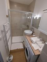 a bathroom with a sink and a washing machine at Le Majorelle-centre ville-accès 24h- parking free in Montluçon