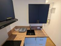 a kitchen with a counter with a sink and blue cabinets at Le Majorelle-centre ville-accès 24h- parking free in Montluçon