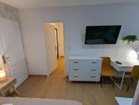 a room with a desk and a tv on a wall at Le Majorelle-centre ville-accès 24h- parking free in Montluçon