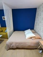a bed in a room with a blue wall at Le Majorelle-centre ville-accès 24h- parking free in Montluçon