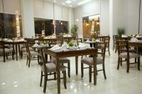 Un comedor con mesas y sillas de madera. en Seraj Amman Hotel, en Amán