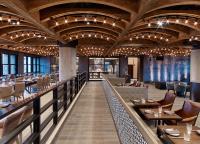 ein Restaurant mit Holzdecken und Tischen und Stühlen in der Unterkunft Hotel Van Zandt in Austin