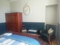 a bedroom with a chair and a clock on the wall at Thunder Roadhouse in La Mothe-Saint-Héray