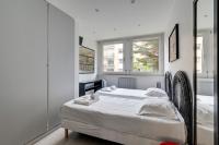 a white bedroom with a bed and two windows at 236 Home Rome Concept in Paris