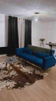 a living room with a blue couch and a table at Appartement cosy de standing in Mondonville