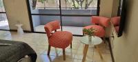 una habitación con 3 sillas y una mesa con un jarrón en Apex Apart, en Mendoza