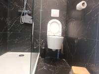 a bathroom with a toilet and a black wall at La Marée, Studio vu mer Le Havre in Le Havre