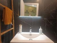 a bathroom with a white sink and a mirror at La Marée, Studio vu mer Le Havre in Le Havre