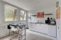 a kitchen with white cabinets and a table with chairs at 235 Home Madrid Concept in Paris