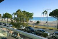 a view of a parking lot with cars and the beach at Tiercé Hotel in Cagnes-sur-Mer