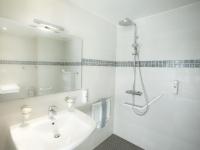 a white bathroom with a sink and a shower at Tiercé Hotel in Cagnes-sur-Mer