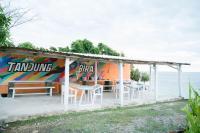 een paviljoen met tafels en stoelen voor de oceaan bij Woywoy Paradise in Bira