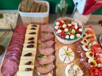 Dworek Szumilas في برودنيك: طاولة مغطاة بالجبن واللحوم وطبق من الفاكهة