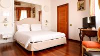 a bedroom with a white bed and a television at Cà Doge in Venice