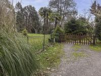 a wooden fence with a gate in a field at Holiday Home Le chant des milans by Interhome in Ondres