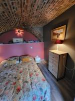 a bedroom with a large bed with a wooden ceiling at Appartement de charme et jardin in Bihorel